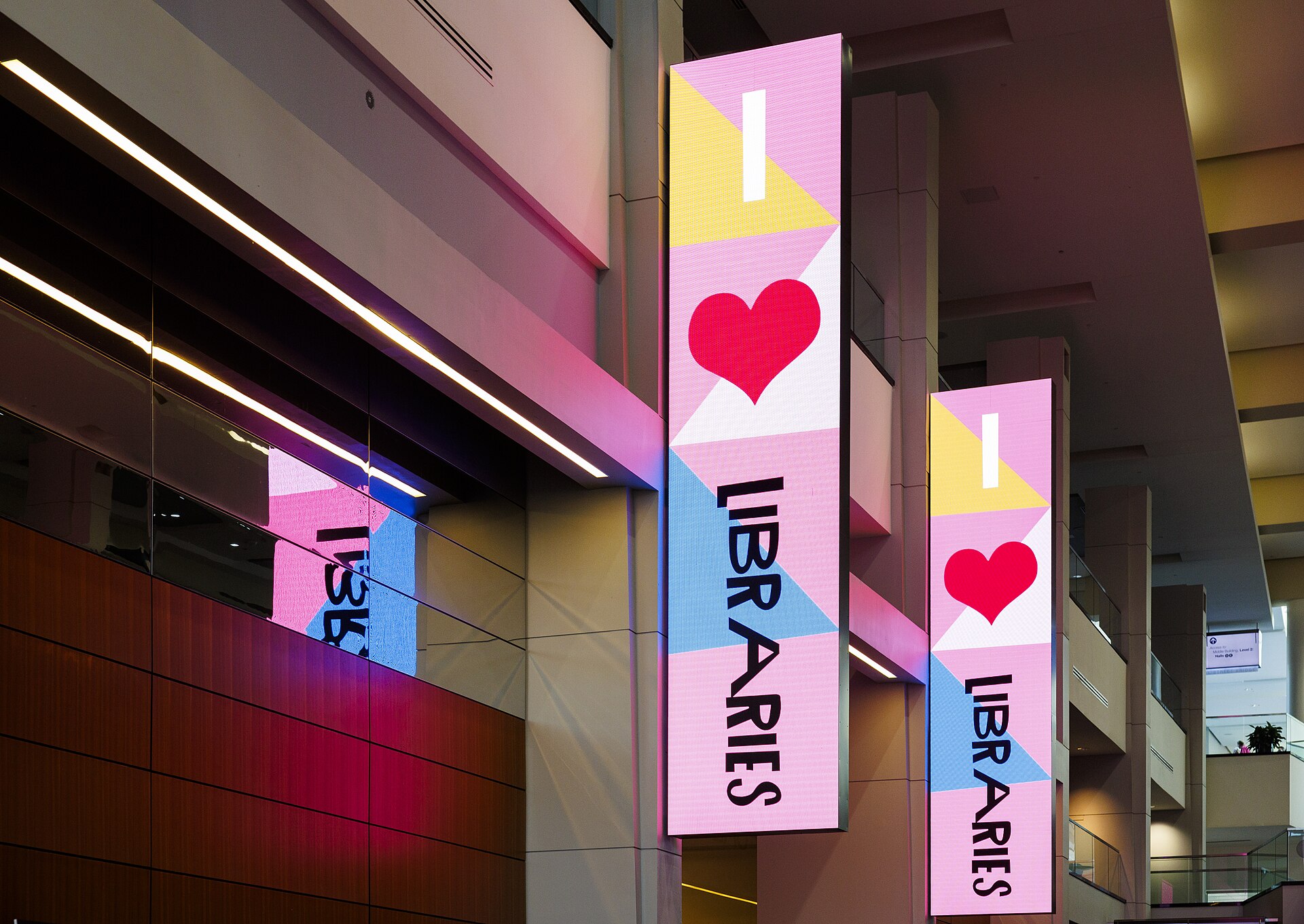 Tall LED columns showing event graphics at the entrance of a convention center